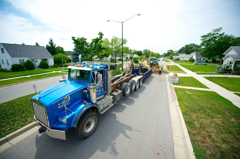 A Bob Frame Plumbing vac truck on a city street repair